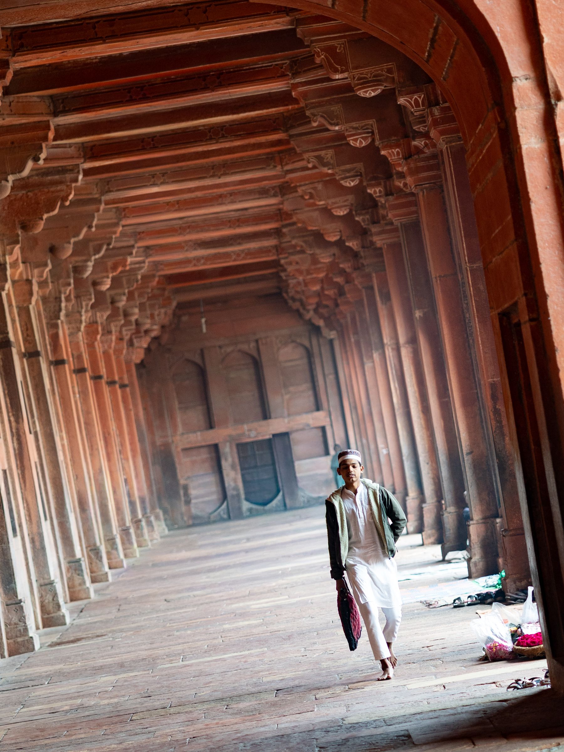 Red Sandstone Colonnade With Walking Acolyte